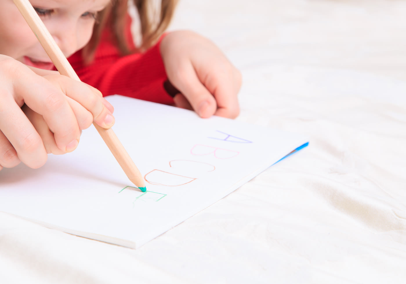 Parent supporting a child while writing and documenting learning